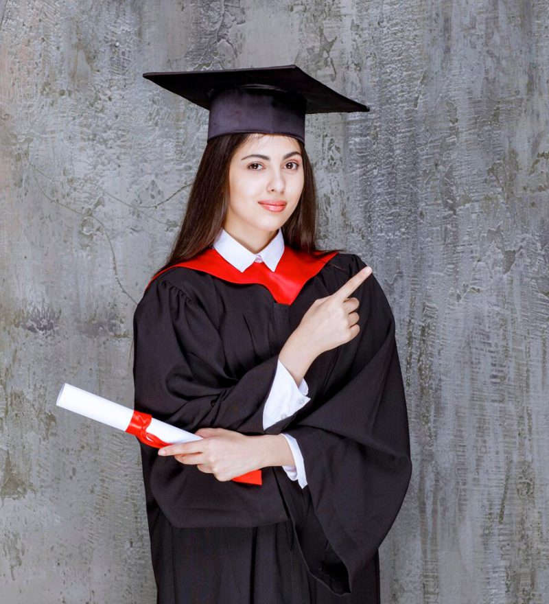 photo-female-student-wearing-gown-pointing-somewhere-high-quality-photo_144627-73546